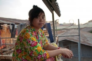 Win, a garment worker, outside her home in Phnom Penh. 