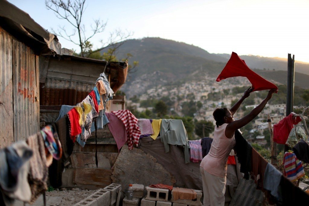 Woman hanging laundry in Haiti shantywon