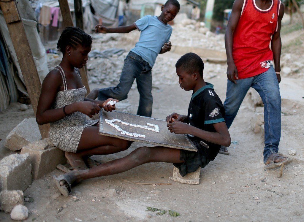 Children play a game of dominoes as they hang out together near their makeshift homes. Photo by Joe Raedle/Getty Images