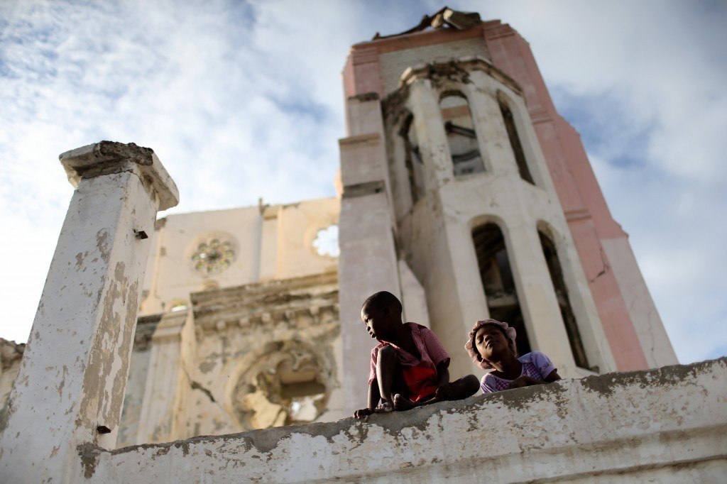 Children sit on the wall next to the National Cathedral that was destroyed five years ago by a magnitude 7.0 earthquake that struck Haiti in 2010. Five years later a church has been built next to the ruins and the city of Port-au-Prince struggles to recover even as the government is locked in a stalemate over parliamentary elections that have been delayed for several years. Photo by Joe Raedle/Getty Images