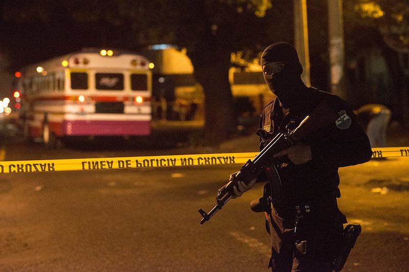 A police officer stands guard after the murder of a bus driver in San Salvador. By Encarni Pindado for NPR