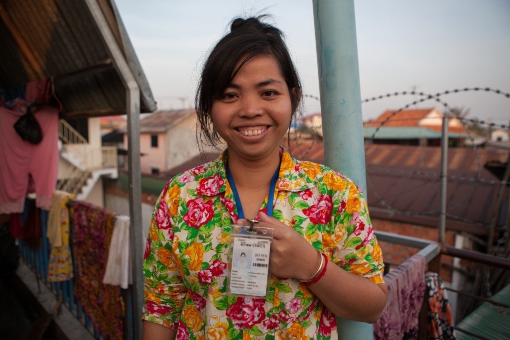 WIC Community Organizer Phorn Srey Win's shows her worker ID tag. Though still in her twenties, Win has been living and working at garment factories in Phnom Penh for nearly 15 years. Photo by Evan Abramson.