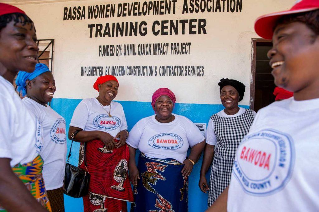 Martha Karnga and her staff share a laugh outside BAWODA’s headquarters in Buchanan, Grand Bassa County.