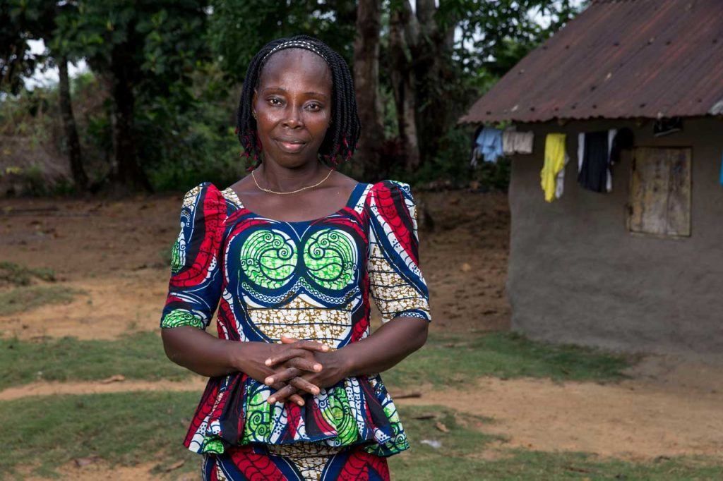 Robertetta Harris poses outside her home in Fortsville, Grand Bassa County.