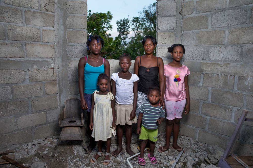 Francoise Inocent stands with her 5 children in a concrete structure without a roof- it is their home. That, along with all of their belongings, was destroyed in the Hurricane.