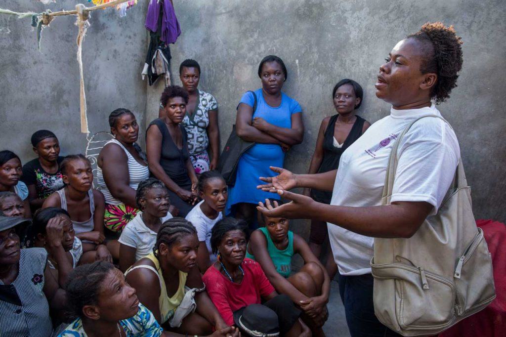 SOFA representative Neslie François stands in front of a group of women, facilitating a meeting about women’s empowerment with community members in Jérémie. Photograph by Jonathan Torgovnik