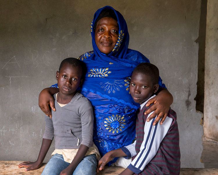 Vamuyan (left) and Kabune (right) lost both their parents to the Ebola virus in August 2014. Since then, their aunt Zainab Kaneh (center) has been caring for them at her home in Banjor, Liberia. (Photo by Jonathan Torgovnik)