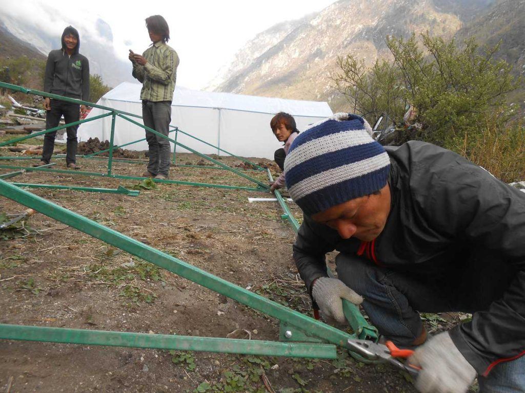 Members of AJWS grantee HCC constructing greenhouses in the arid Langtang Valley that feed dozens of families. Photo by HCC.