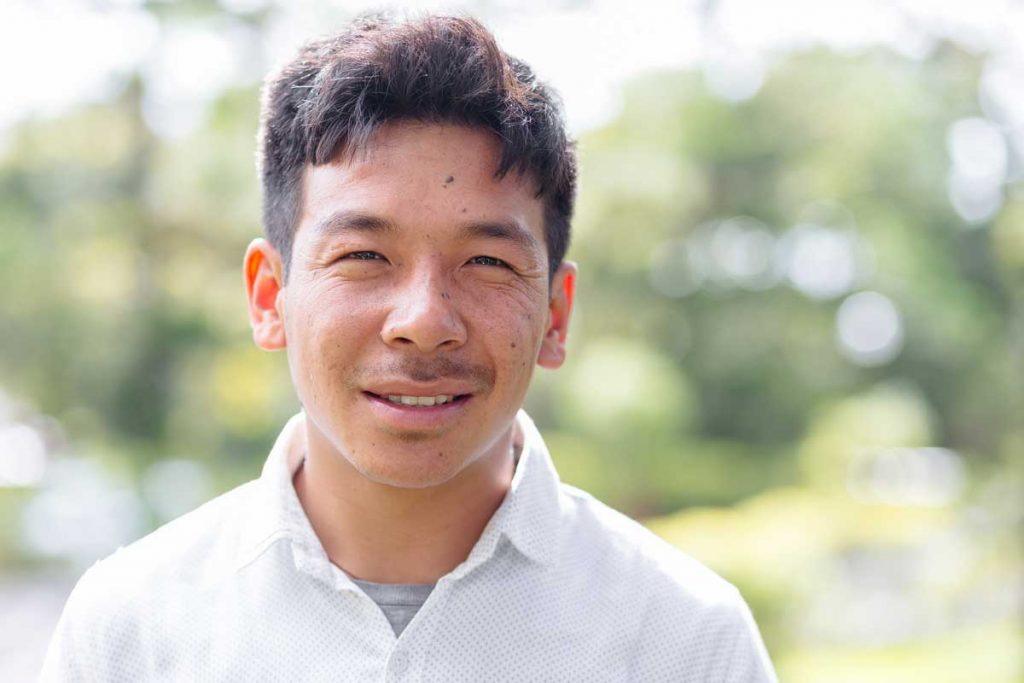 Pasang Tamang, wearing a white collared shirt and looking at the camera with a small smile. He and his colleagues at HCC are aiding their community in Langtang in post-quake recovery efforts. Photo by Ben Beringuela