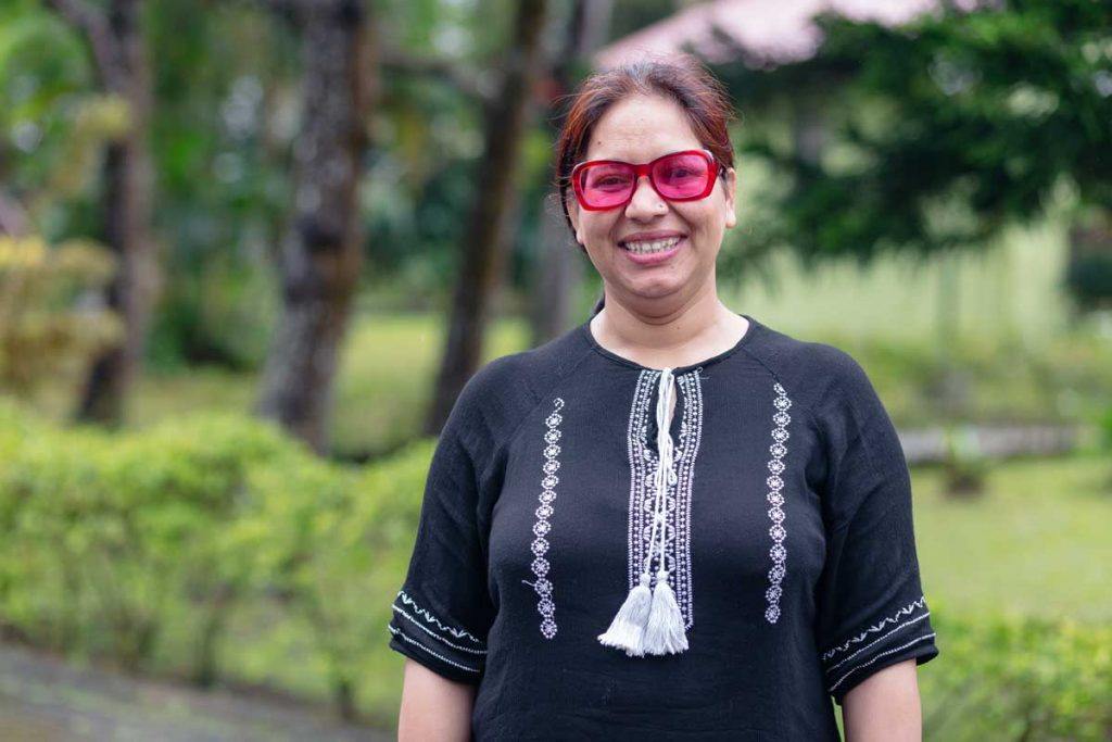 Radhika Sapkota of Sahayatri Samaj has been helping women who have experienced violence attain justice in Nepal. Here, she faces the camera wearing pink sunglasses and smiling. Photo by Ben Beringuela