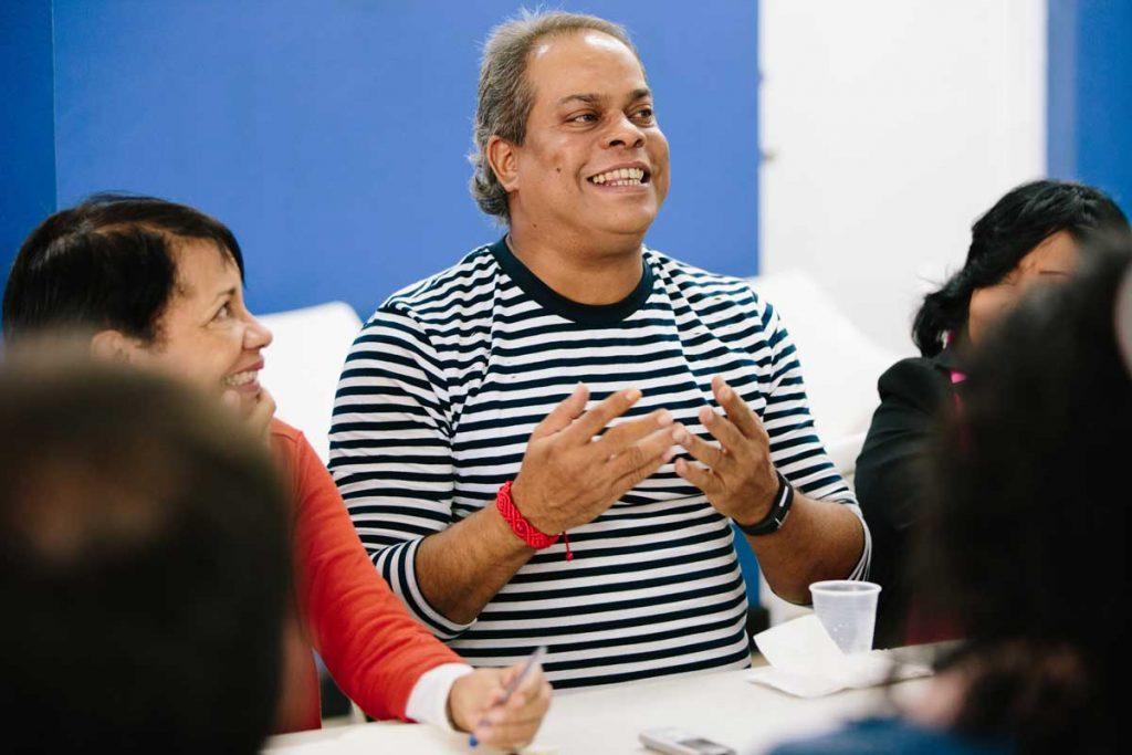 ASA director Leonardo Sanchez, smiling at the center of the photo and gesturing with his hands, tells AJWS Global Justice Fellows about the history of the Dominican LGBT rights movement. Photograph by Christine Han