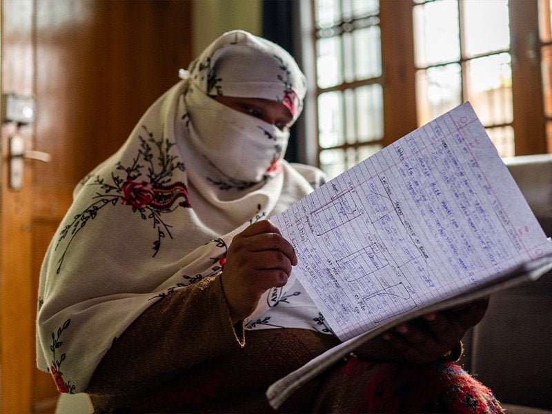 woman looking at papers inside a room with windows in the background