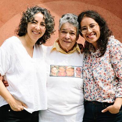 three women smiling together at the camera