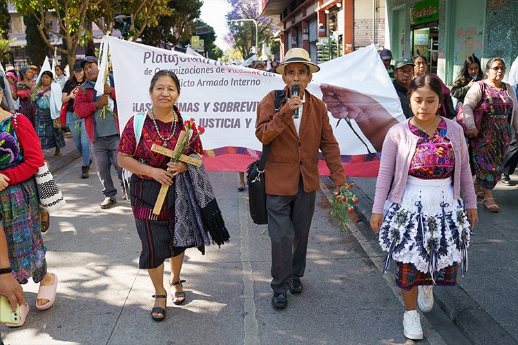 rally of people marching through the street with signs
