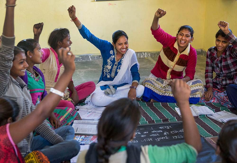 young women sitting in a circle and smiling
