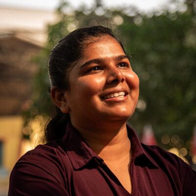 young woman smiling up at the sun