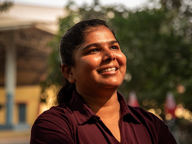 young woman smiling up at the sun