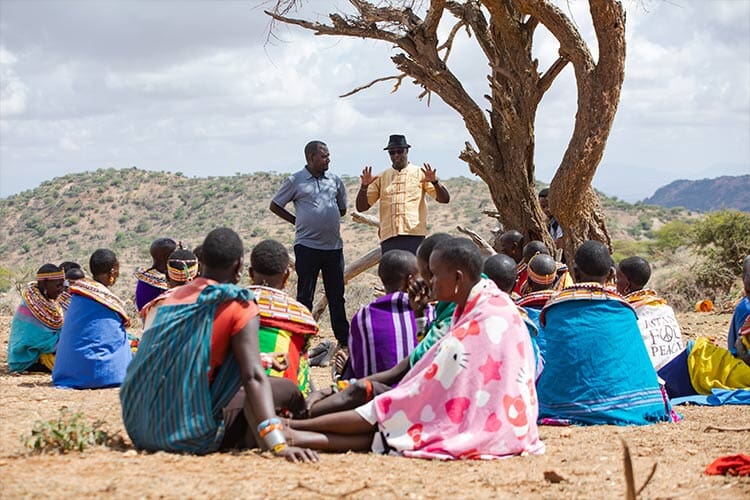 group of people standing next to a tree