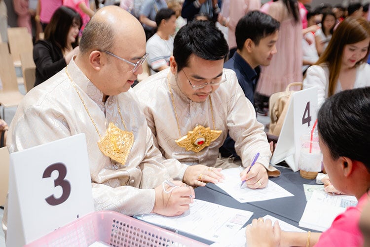 two men signing marriage license, looking down and writing