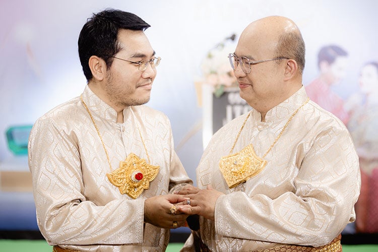 two men with glasses looking at each other lovingly