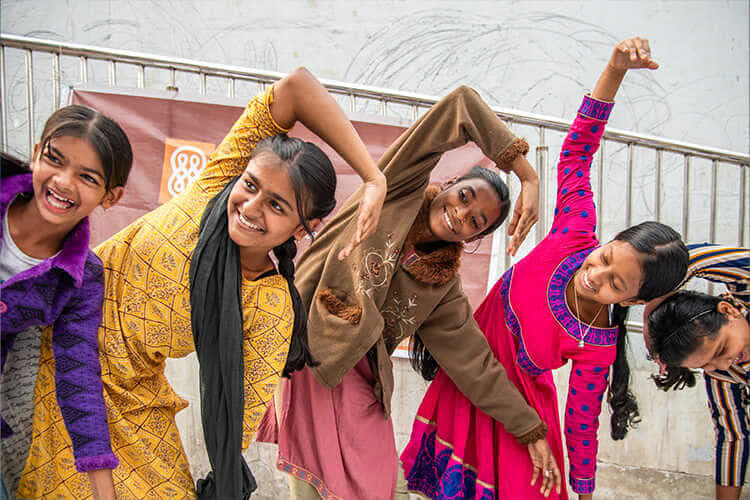 five young girls smiling and doing an activity together
