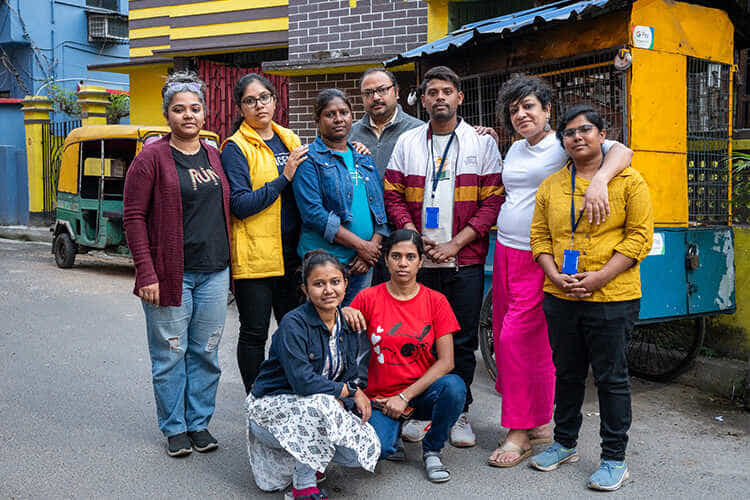 group of about 10 people standing together in front of a building