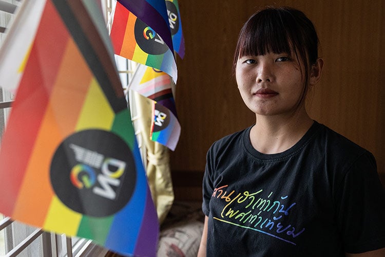 image of woman looking at camera surrounded by pride flags