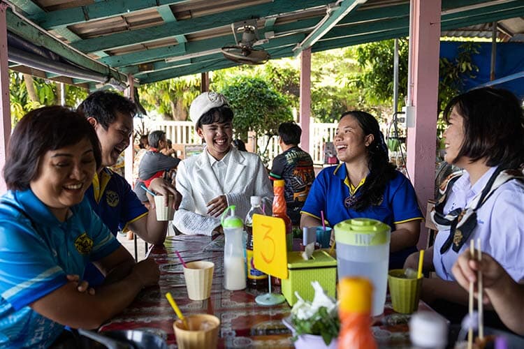 group of people smiling and eating together