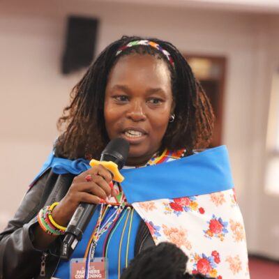 A woman holding a microphone and speaking.