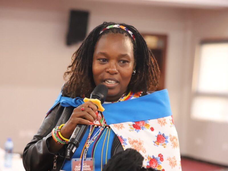 A woman holding a microphone and speaking.