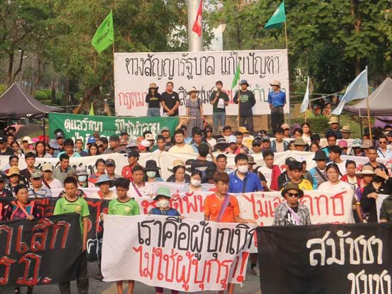large group of people outside holding banners