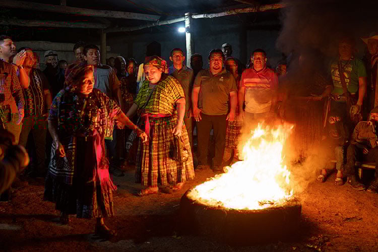 firepit blazing with people gathered around