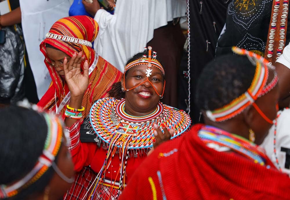 woman smiling and wearing red traditional attire and headpiece