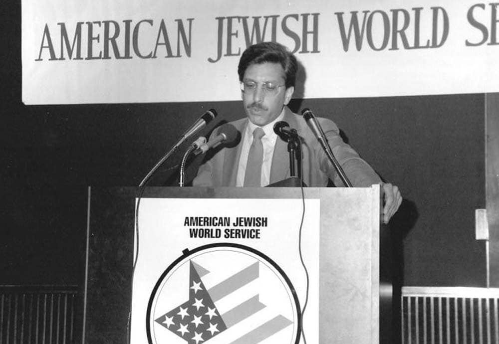 Larry Simon at podium, black and white