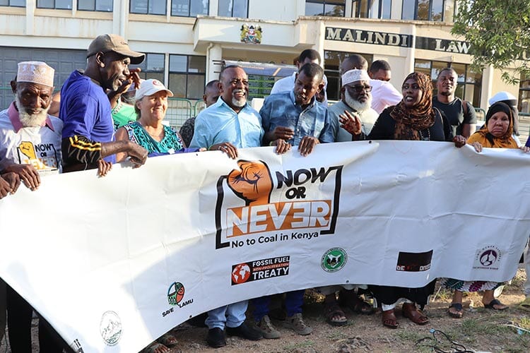 group of people holding up a white banner