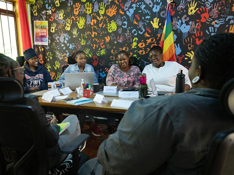 six people sitting around a table together