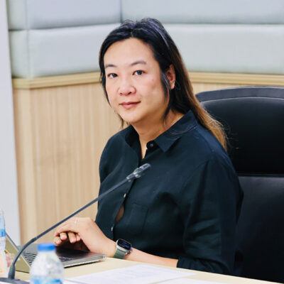 Hua looking at camera while seated at a desk