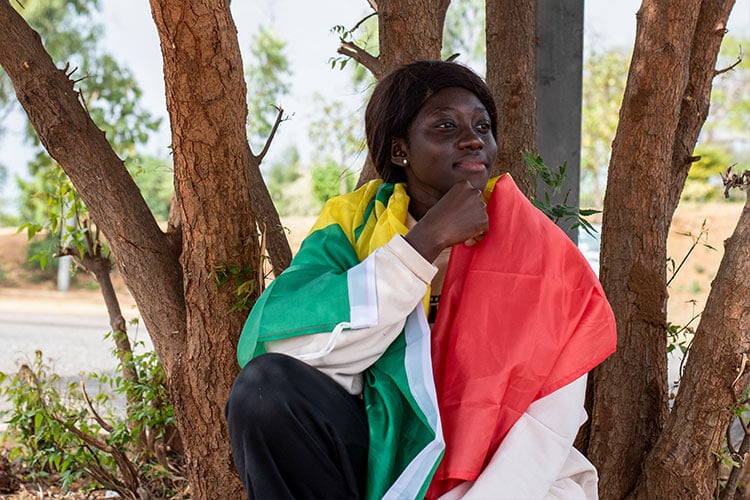 young woman posed in front of a tree