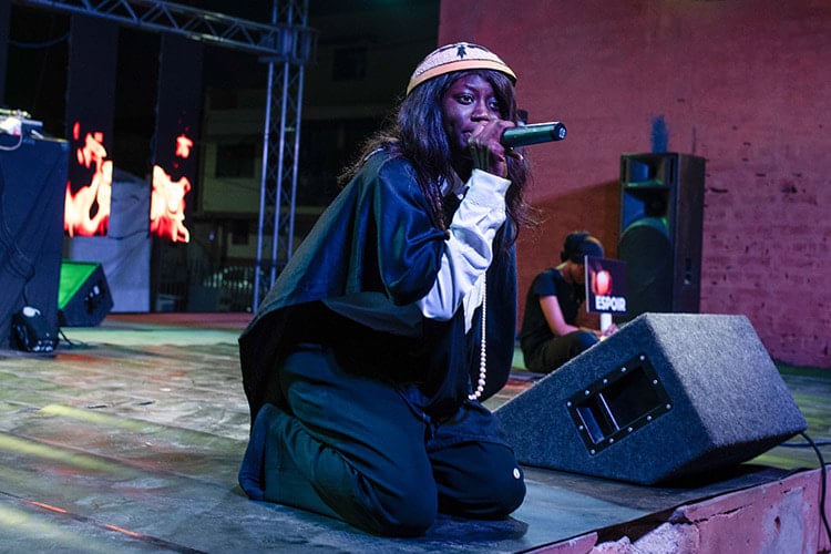 young woman performing on stage, holding a mic