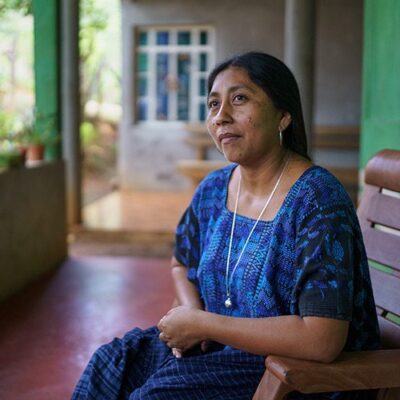 woman in blue dress sitting on a porch