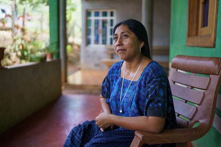 woman in blue dress sitting on a porch