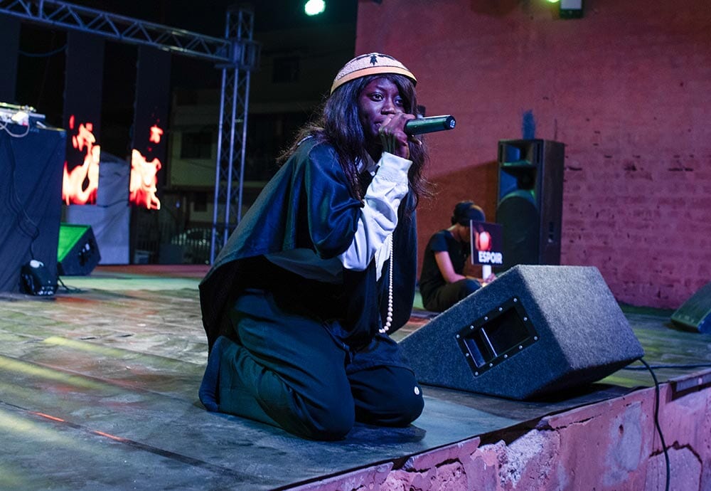 young woman speaking into mic on stage