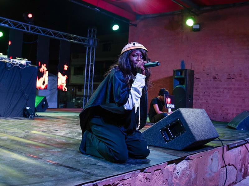 young woman speaking into mic on stage