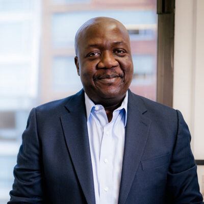 Tawanda Mutasah in a suit smiling at camera