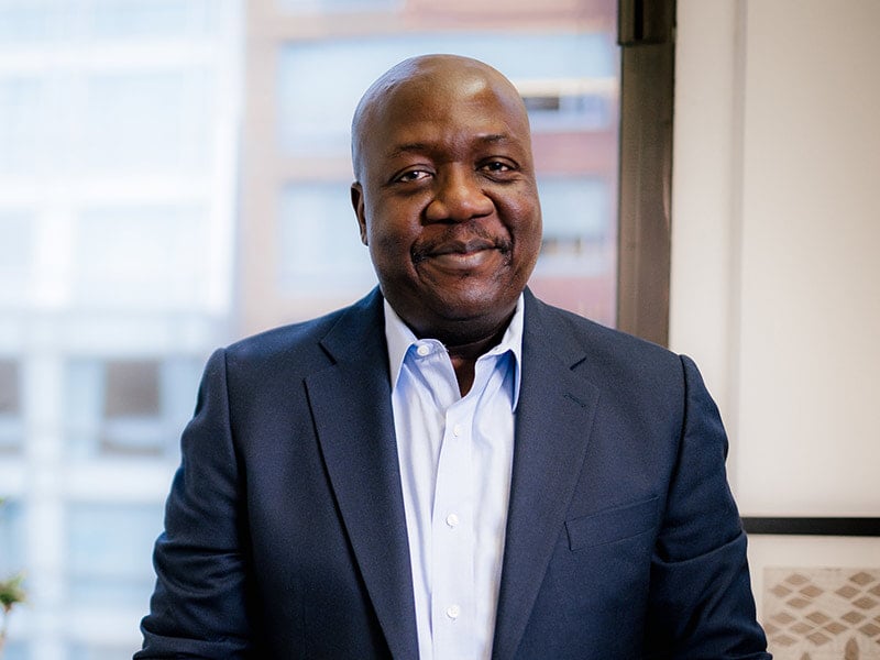 Tawanda Mutasah in a suit smiling at camera