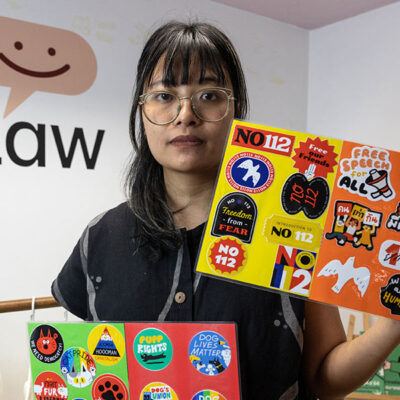 woman holding up colorful signs