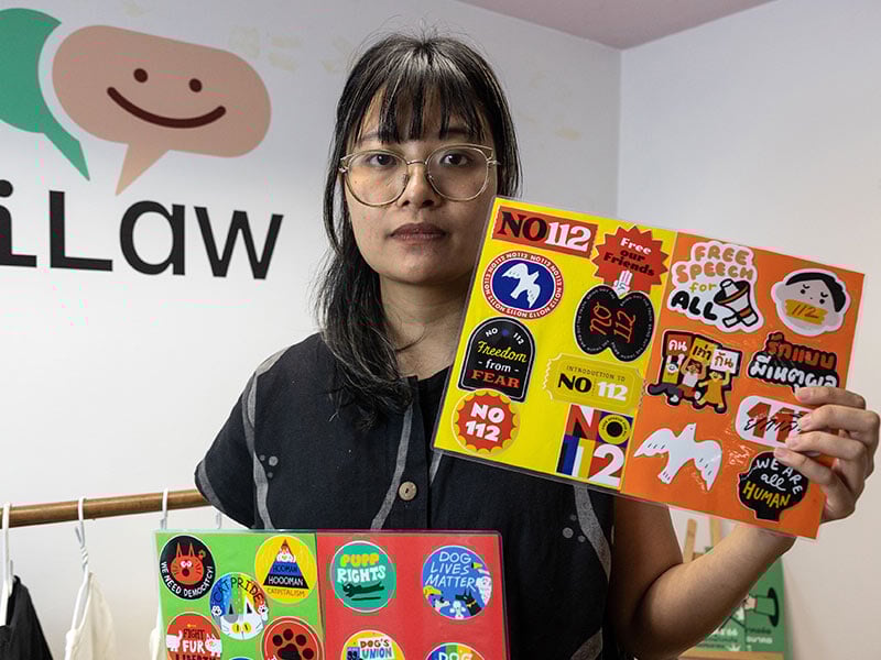 woman holding up colorful signs