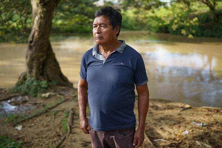 man standing in front of brown river