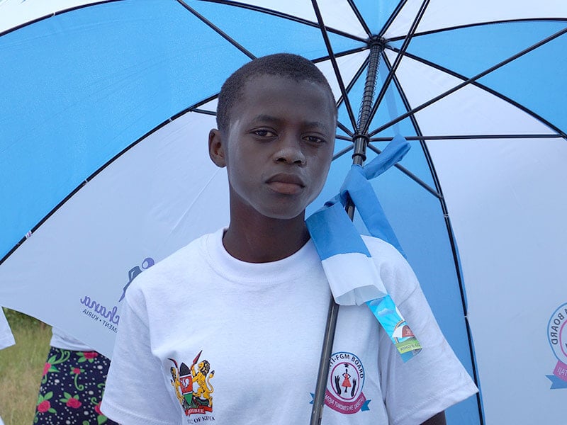 young girl looking at camera, holding an umbrella