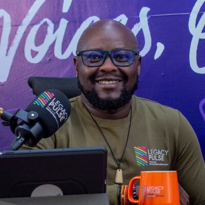 man smiling at camera in front of a mic